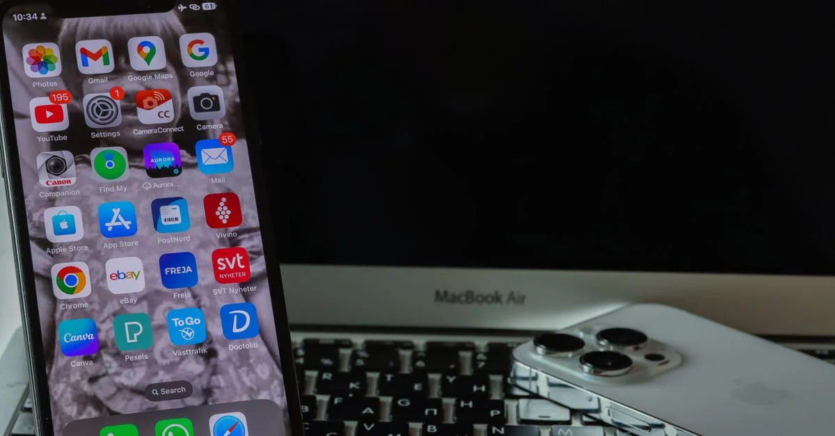 Une configuration de smartphone et d'ordinateur portable mettant en avant un agencement technologique moderne et élégant sur un bureau.