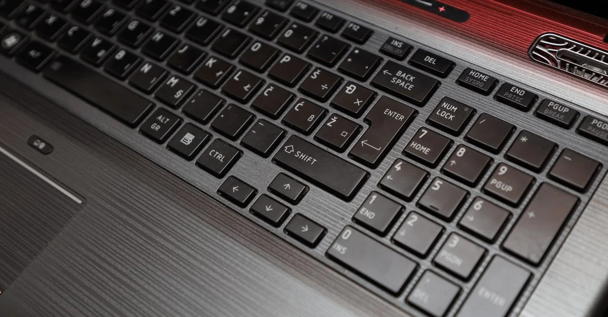 Vue en plongée d'un clavier d'ordinateur portable avec pavé numérique et design épuré.