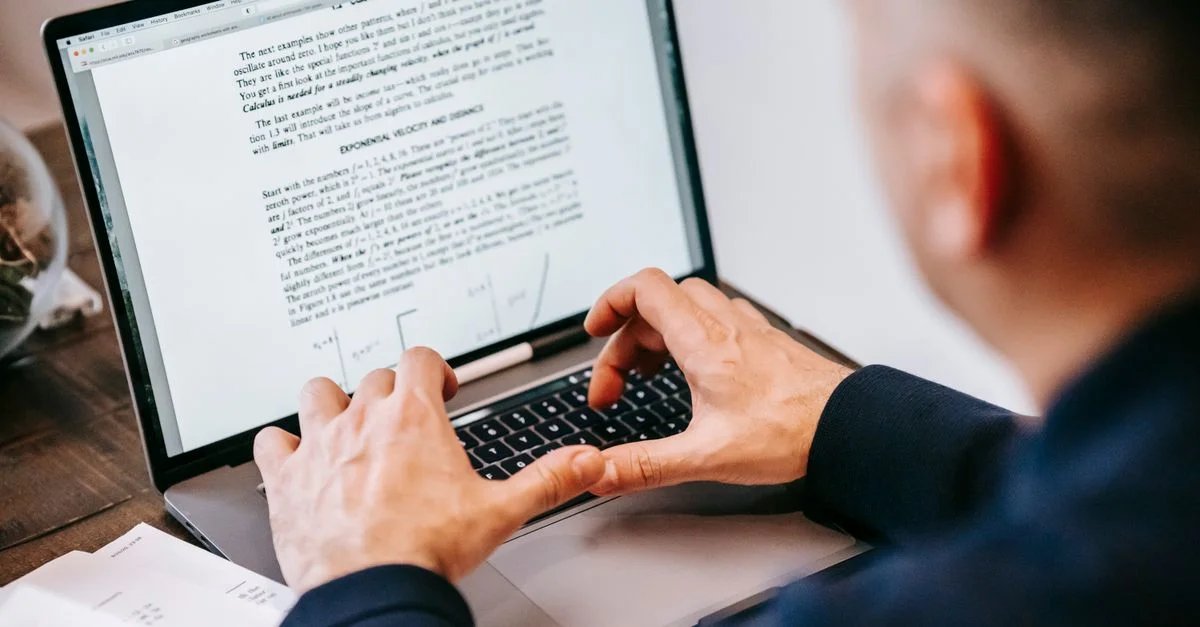 Homme tapant sur un ordinateur portable dans un bureau à domicile, concentré sur son travail, illustrant le mode de vie du télétravail.